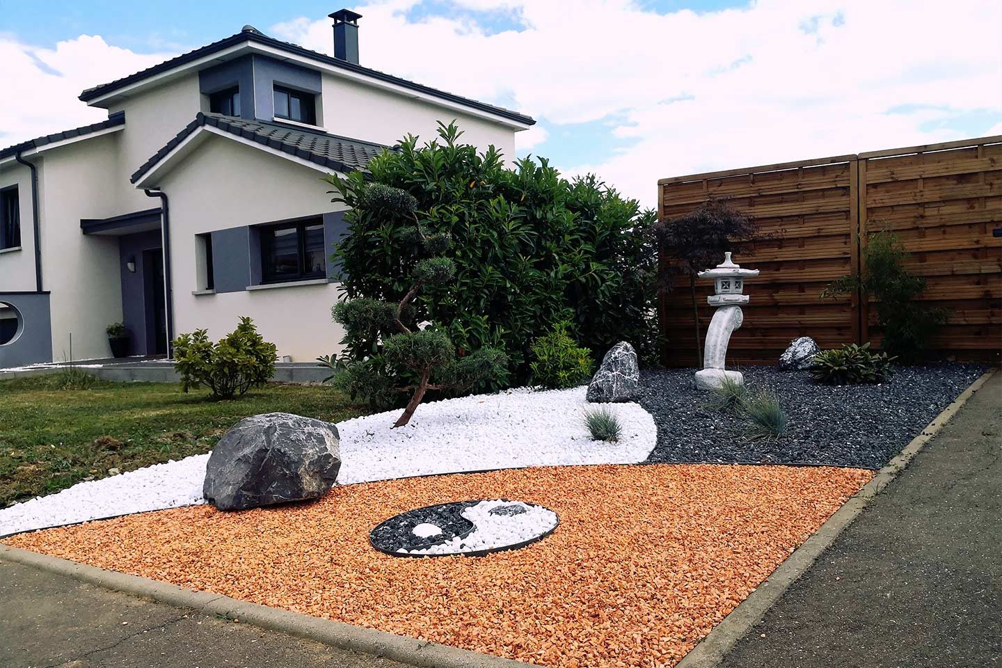 Jardin japonais : gravier rouge, galets blancs, ardoise, lanterne et yin-yang de pierres